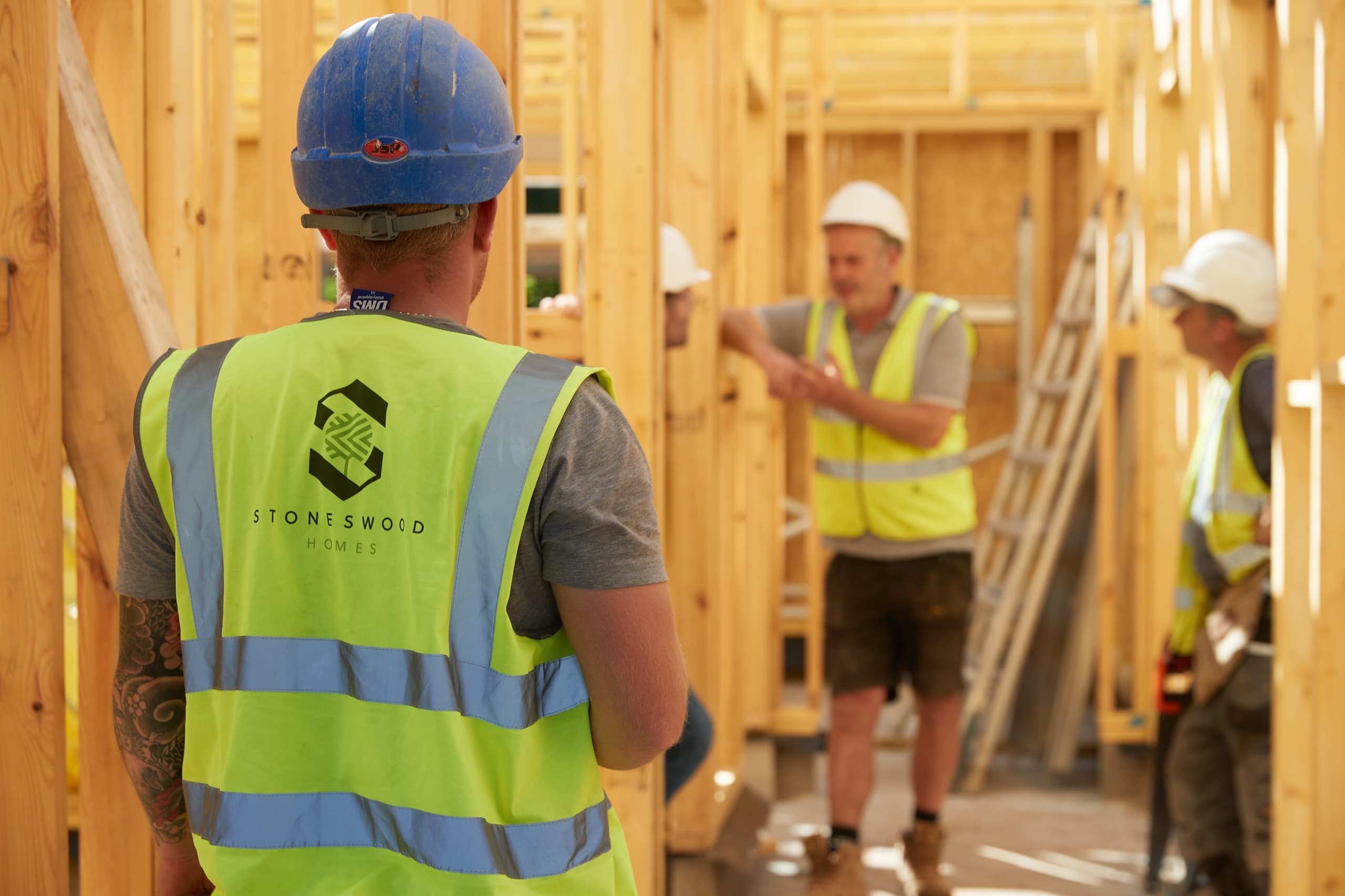 The Stoneswood team on site in branded hi-vis, framing a new home in timber